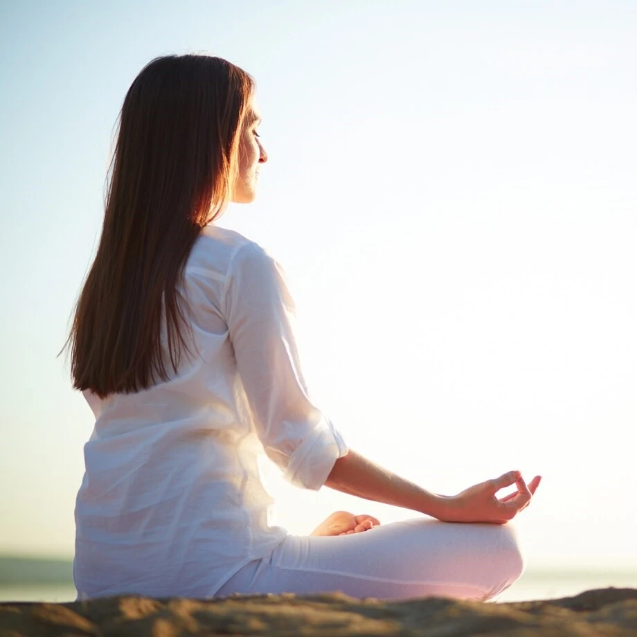 Femme en posture de méditation sur la plage